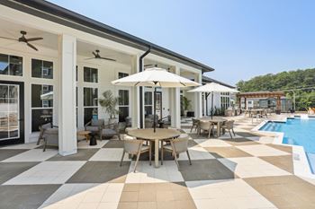 A patio with a table and chairs and an umbrella.